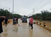 Respons Cepat Laporan Call Center 110, Polsek Padang Tualang Atur Lalu Lintas di Jalan Sumur Bor yang Tergenang Air