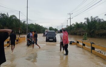 Respons Cepat Laporan Call Center 110, Polsek Padang Tualang Atur Lalu Lintas di Jalan Sumur Bor yang Tergenang Air