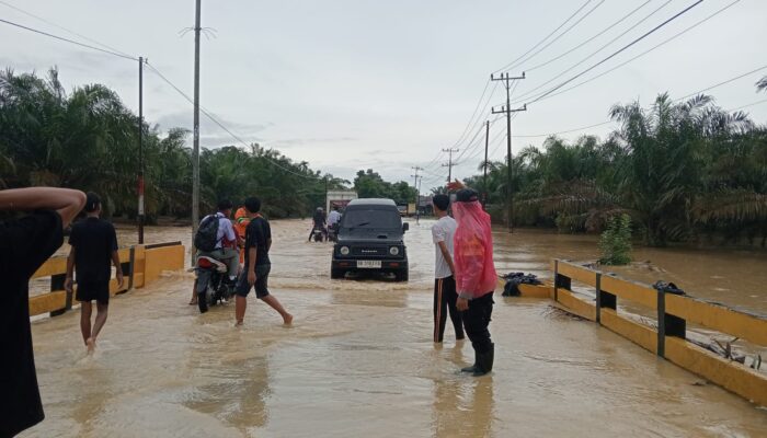 Respons Cepat Laporan Call Center 110, Polsek Padang Tualang Atur Lalu Lintas di Jalan Sumur Bor yang Tergenang Air